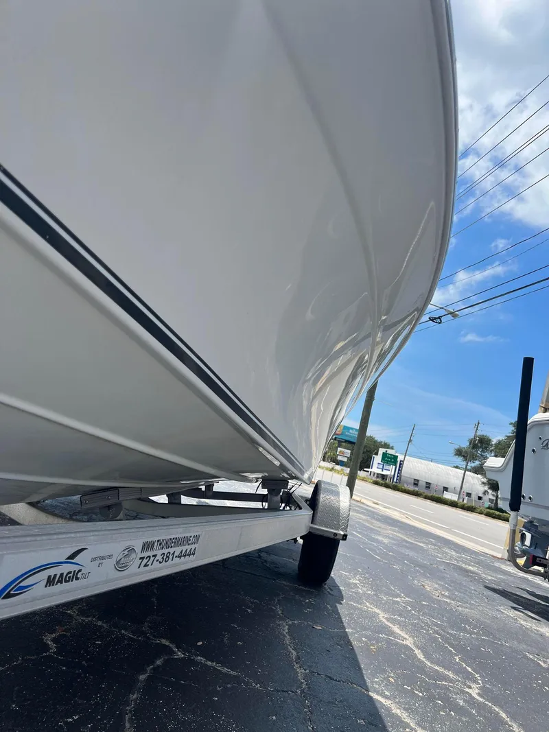 Slide: The Image of 2015 NauticStar 2110 Sport boat on trailer, side view under clear sky. - 8