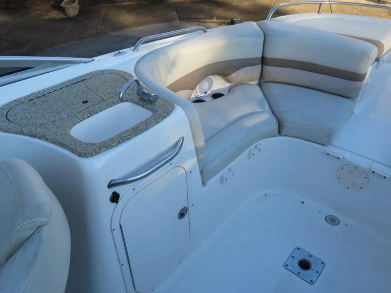 Slide: The Image of 2004 Chaparral 256 SSi boat interior with white seating and storage compartments. - 4