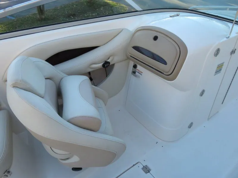 Slide: The Image of 2004 Chaparral 256 SSi boat interior with beige seating and dashboard. - 8