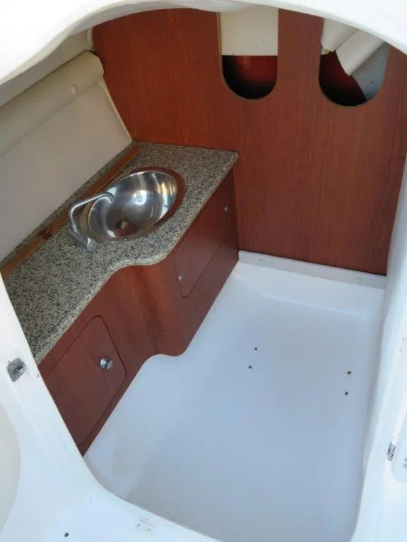 Slide: The Image of 2004 Chaparral 256 SSi boat interior with sink and wooden cabinetry. - 9