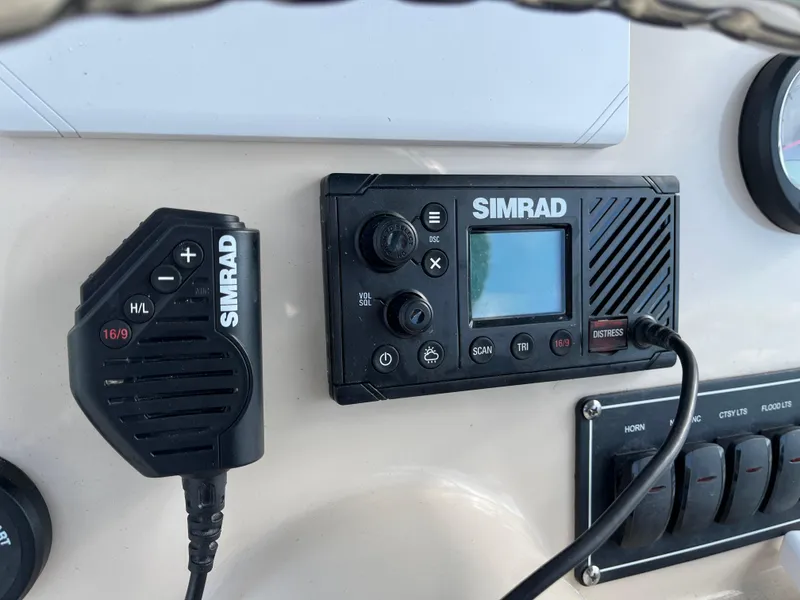 Slide: The Image of Simrad marine radio system on 2024 Boston Whaler 230 Outrage dashboard. - 16