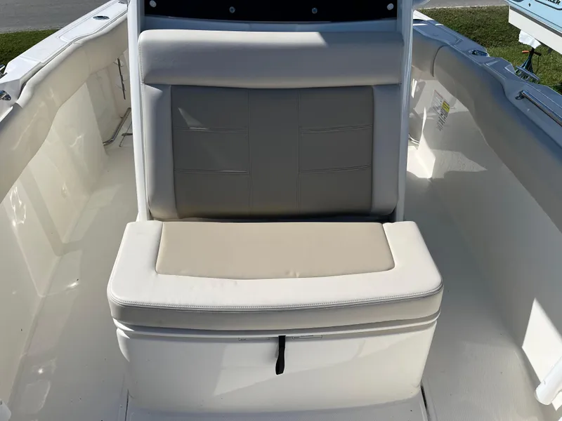 Slide: The Image of 2024 Boston Whaler 230 Outrage boat seating area with cushioned bench. - 23