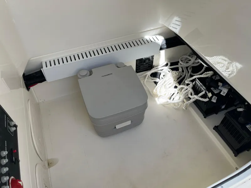 Slide: The Image of 2024 Boston Whaler 230 Outrage storage compartment with ropes and equipment. - 5