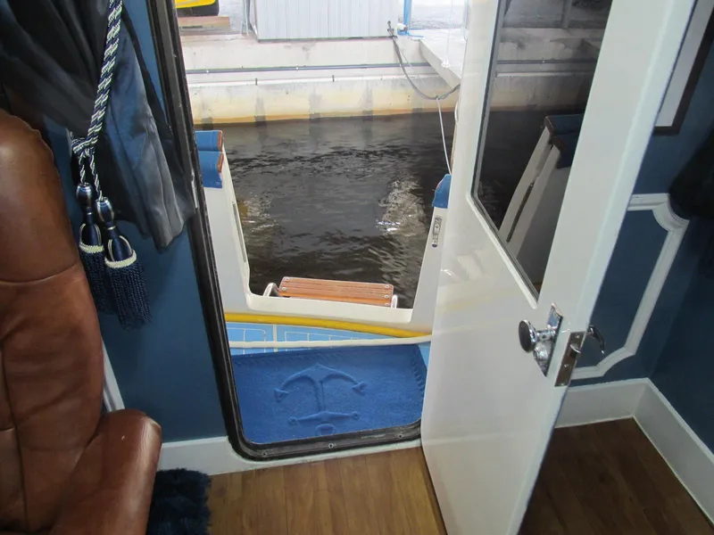 Slide: The Image of 1988 Vista 49 Motor Yacht interior view with open door to deck and water. - 42