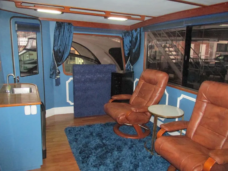 Slide: The Image of Interior of 1988 Vista 49 Motor Yacht with leather chairs and blue decor. - 45