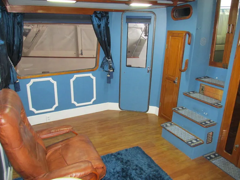 Slide: The Image of 1988 Vista 49 Motor Yacht interior with blue walls, wooden flooring, and leather seating. - 46