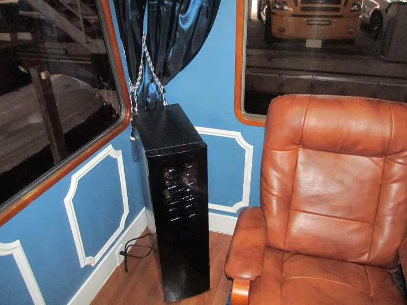Slide: The Image of 1988 Vista 49 Motor Yacht interior with leather chair and blue curtains. - 48