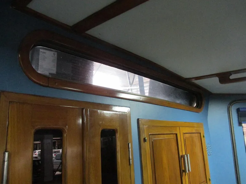 Slide: The Image of Interior of 1988 Vista 49 Motor Yacht with wooden cabinetry and elongated window. - 50