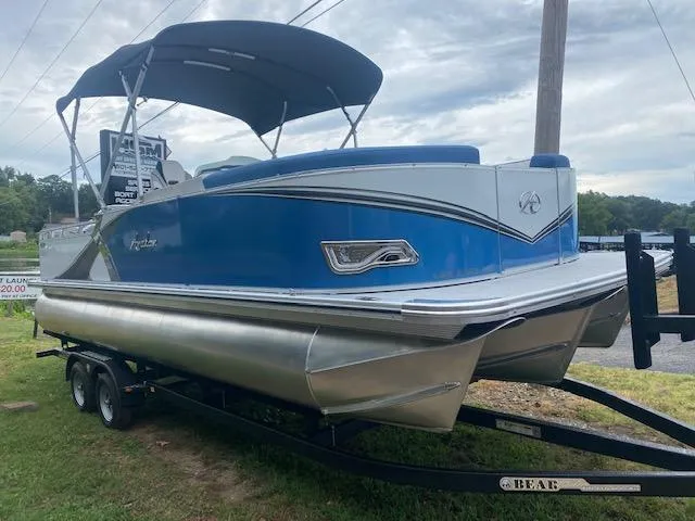 Slide: The Image of 2024 Avalon LSZ 2385 VRL pontoon boat with blue exterior on trailer. - 2