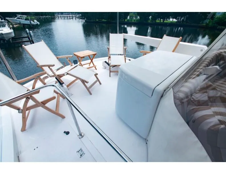 Slide: The Image of 2006 Hatteras 64 Motor Yacht deck with chairs overlooking serene water. - 20
