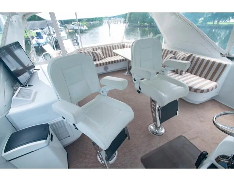 Slide: The Image of Interior of 2006 Hatteras 64 Motor Yacht with plush seating and helm chairs. - 21
