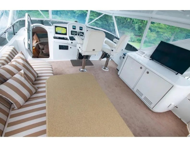 Slide: The Image of 2006 Hatteras 64 Motor Yacht interior with helm, seating, and TV. - 23