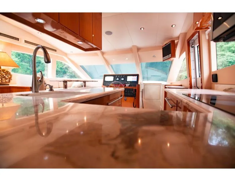 Slide: The Image of Luxurious interior of 2006 Hatteras 64 Motor Yacht with modern kitchen and helm. - 29