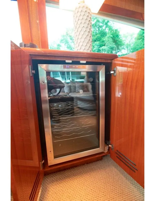 Slide: The Image of Wine cooler in 2006 Hatteras 64 Motor Yacht interior, wooden cabinetry, natural light. - 34