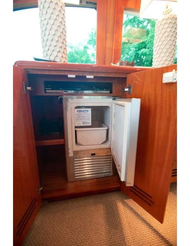 Slide: The Image of 2006 Hatteras 64 Motor Yacht interior with open cabinet and built-in mini fridge. - 35