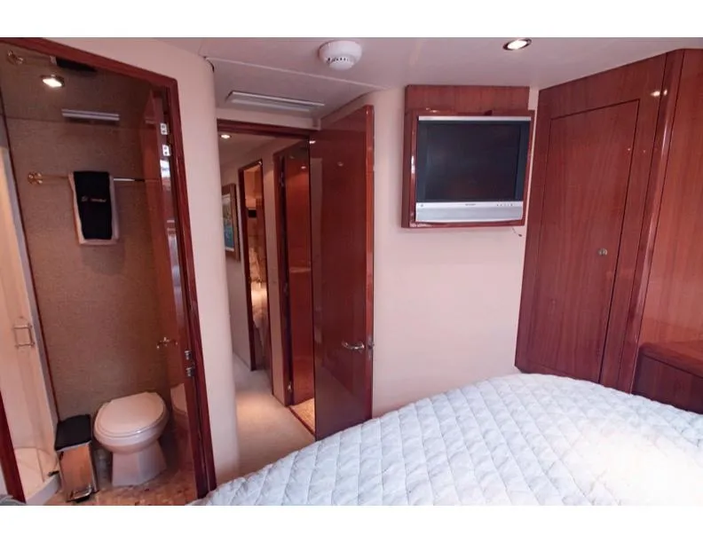Slide: The Image of Interior of 2006 Hatteras 64 Motor Yacht bedroom with ensuite bathroom and TV. - 43