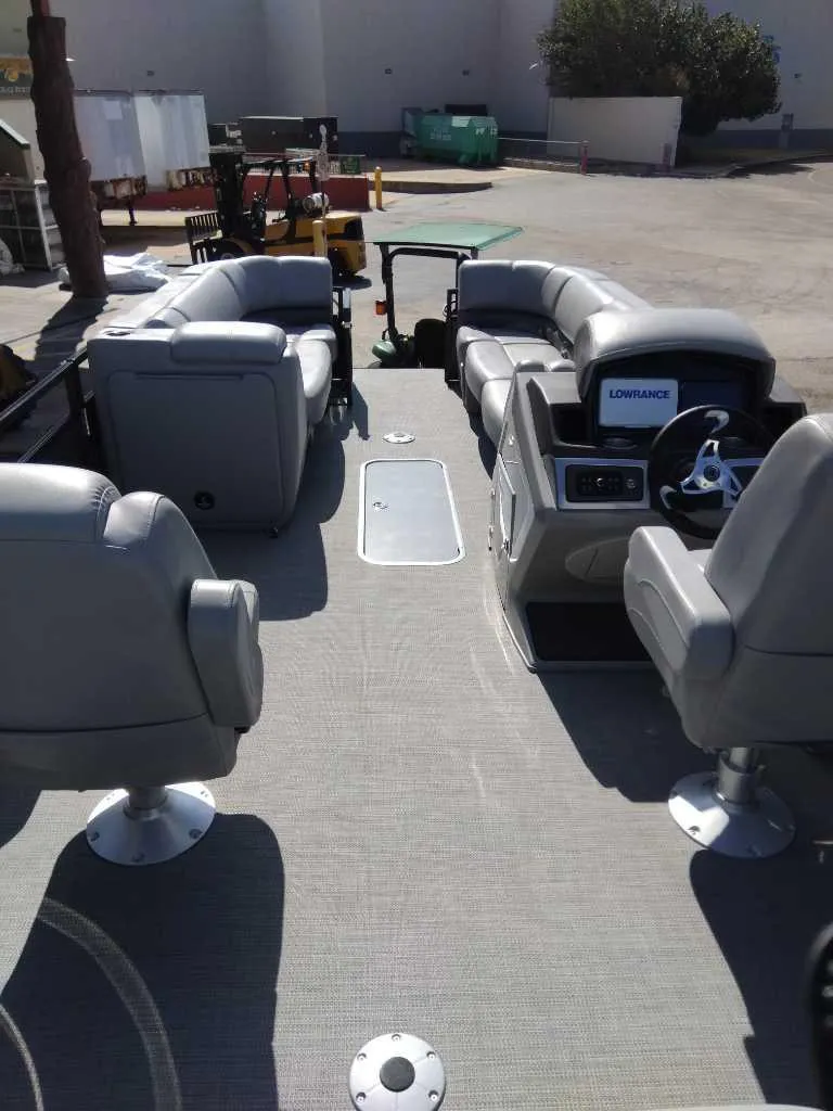 Slide: The Image of 2024 Regency 250 DL3 pontoon boat interior with seating and steering console. - 2