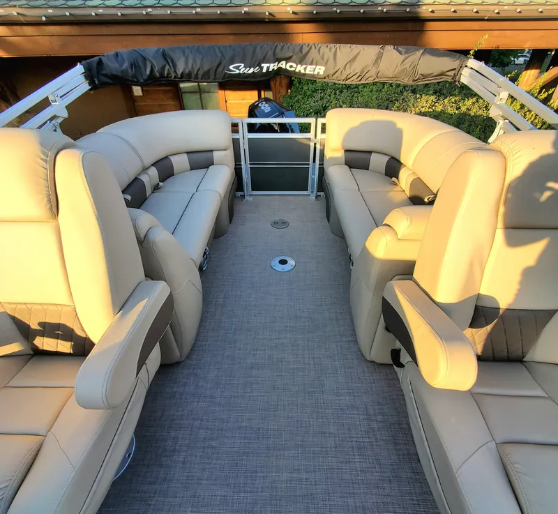 Slide: The Image of 2024 Sun Tracker Party Barge 22 XP3 interior with beige seating and spacious layout. - 2
