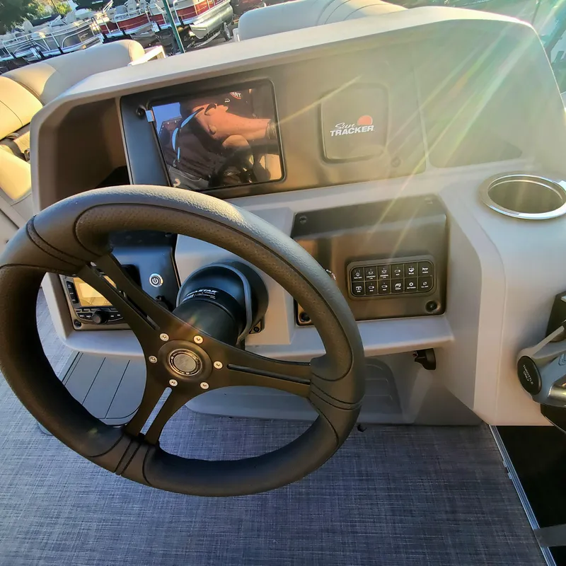 Slide: The Image of 2024 Sun Tracker Party Barge 22 XP3 steering console with sunlight reflections. - 3