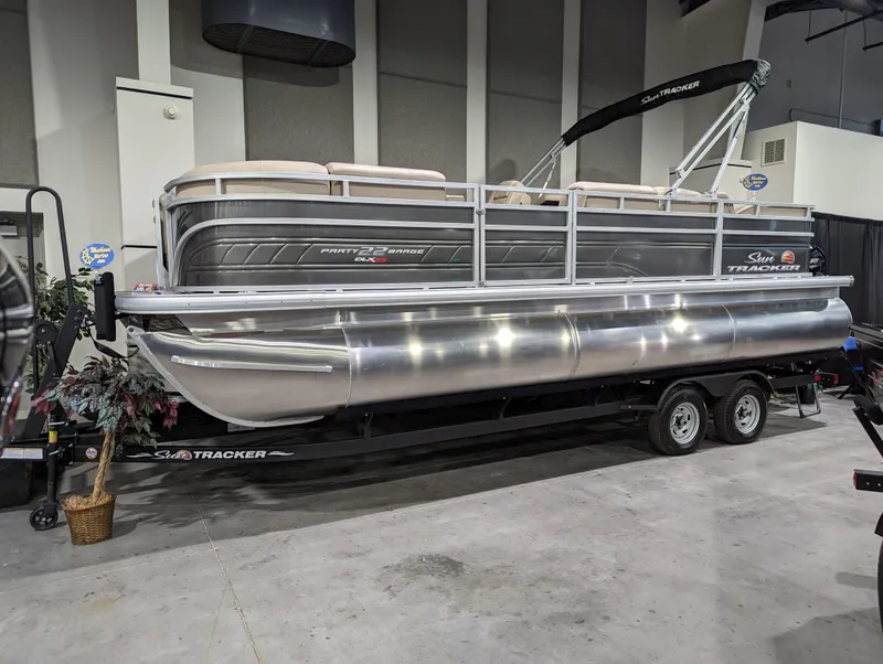 The Image of 2024 Sun Tracker Party Barge 22 RF XP3 pontoon boat on display indoors. - 0