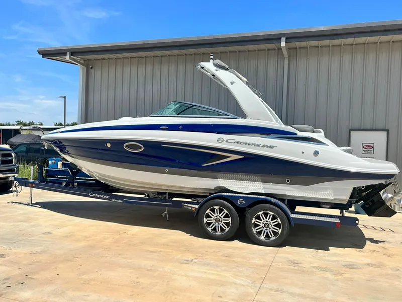 Slide: The Image of 2024 Crownline 270SS boat on trailer, parked outside a building. - 12