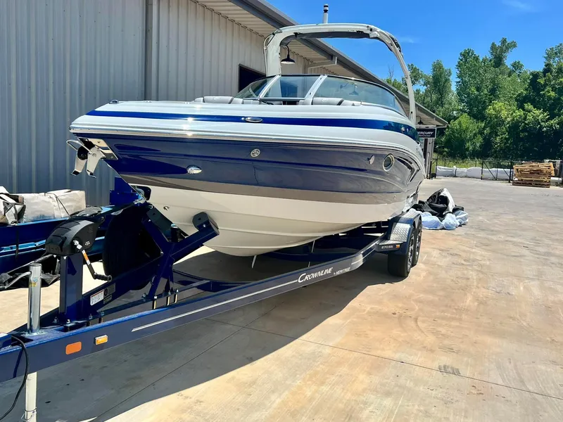 Slide: The Image of 2024 Crownline 270SS boat on trailer, parked outdoors near a building. - 17