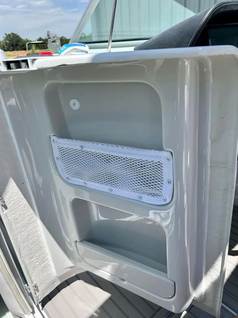 Slide: The Image of 2024 Crownline 270SS boat interior storage compartment with mesh pocket. - 19