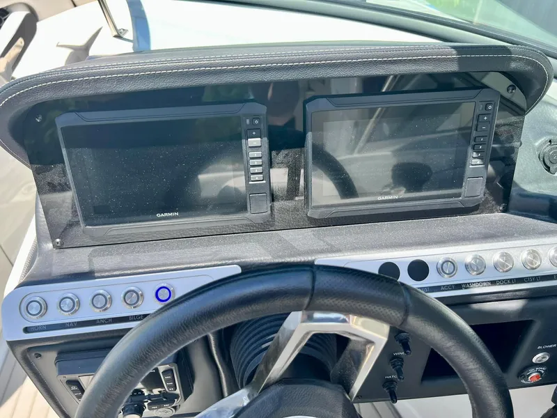 Slide: The Image of 2024 Crownline 270SS dashboard with dual Garmin displays and control buttons. - 21