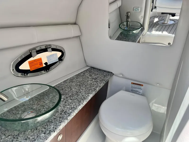 Slide: The Image of 2024 Crownline 270SS boat bathroom with granite countertop and glass sink. - 7