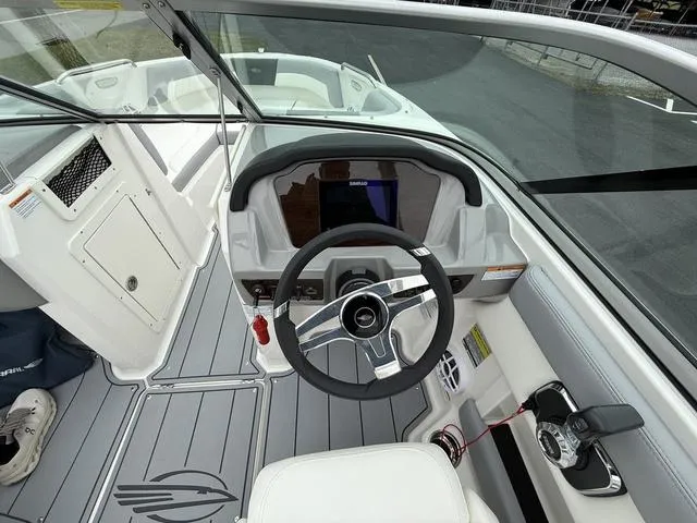 Slide: The Image of 2024 Chaparral 21 SSi boat cockpit with steering wheel and dashboard controls. - 11