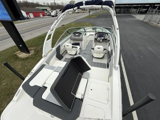 Slide: The Image of 2024 Chaparral 21 SSi boat interior with seating and steering wheel, parked outdoors. - 8