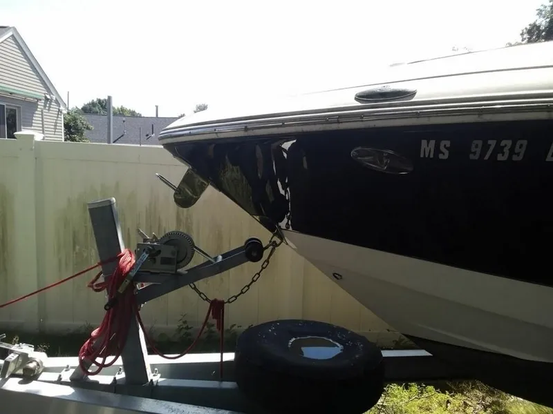 Slide: The Image of 2010 Chaparral 276ssx boat on trailer, parked near white fence. - 3