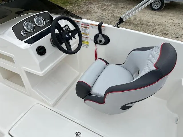 Slide: The Image of 2024 Bayliner Element M19 boat cockpit with steering wheel and captain's chair. - 8