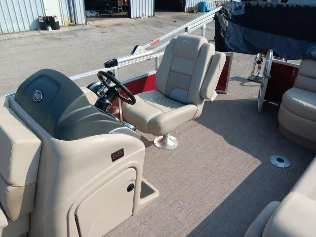 Slide: The Image of 2023 Ranger Reata 223C boat interior with beige seating and steering console. - 28