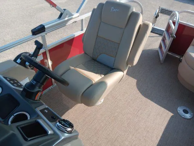 Slide: The Image of 2023 Ranger Reata 223C boat interior with beige captain's chair and steering console. - 33