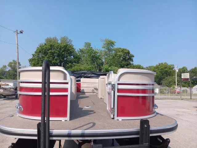 Slide: The Image of 2023 Ranger Reata 223C pontoon boat with red accents, parked outdoors. - 34