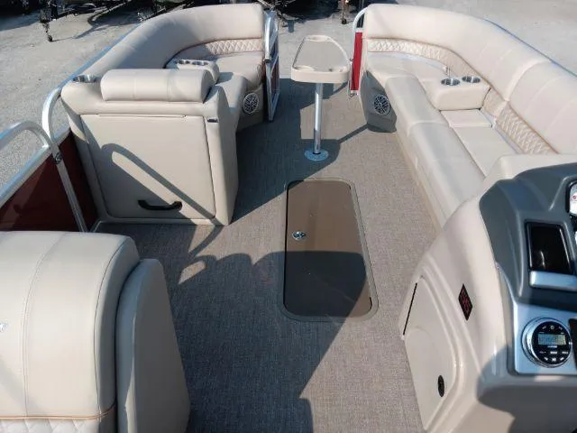 Slide: The Image of 2023 Ranger Reata 223C pontoon boat interior with beige seating and console. - 36