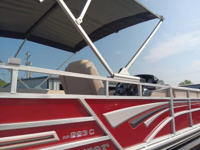 Slide: The Image of 2023 Ranger Reata 223C pontoon boat with red and white design, under a canopy. - 43