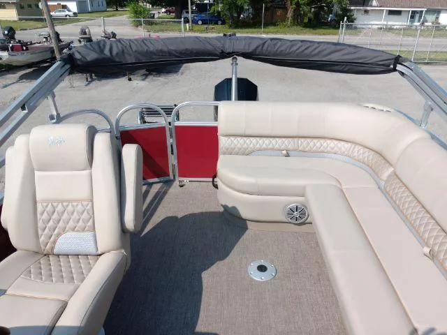 Slide: The Image of 2023 Ranger Reata 223C boat interior with beige seating and red accents. - 45