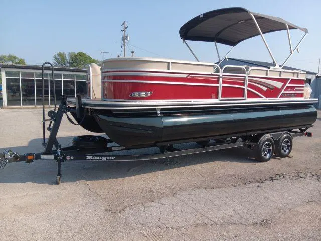 Slide: The Image of 2023 Ranger Reata 223C pontoon boat with red and white design on a trailer. - 48