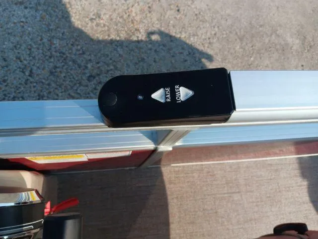 Slide: The Image of 2023 Ranger Reata 223C boat control panel with raise and lower buttons. - 49