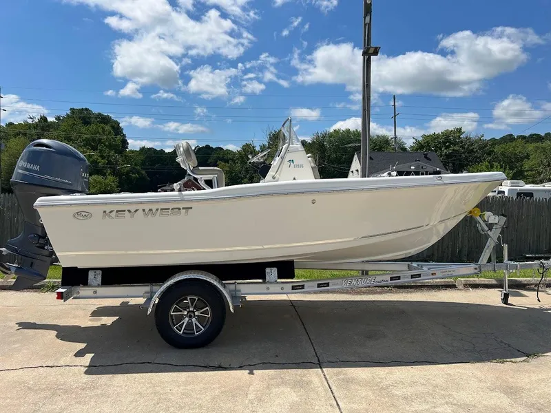 Slide: The Image of 2024 Key West 179 FS boat on a trailer under a clear blue sky. - 0