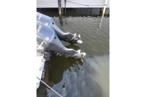 Slide: The Image of Twin outboard motors on a 2015 Sailfish 320 CC boat docked in water. - 29