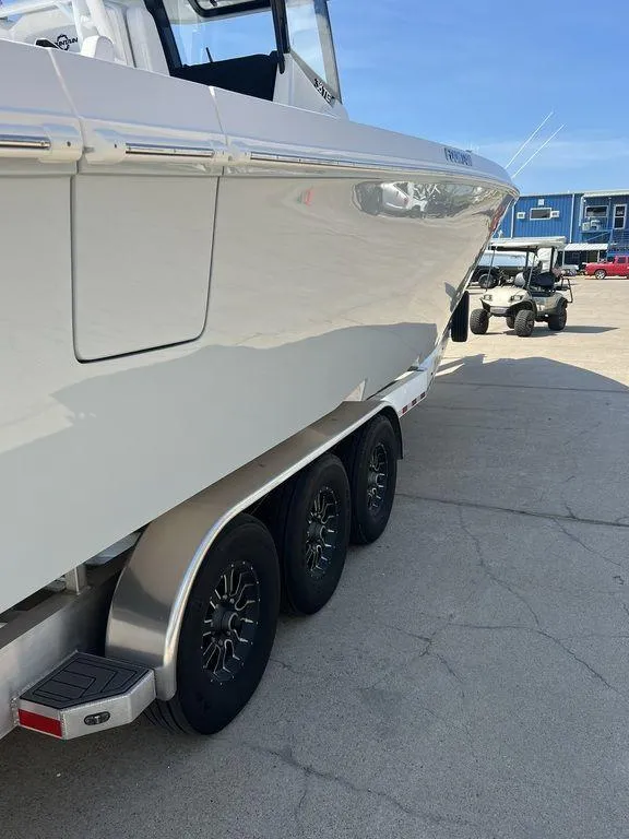 Slide: The Image of 2024 Fountain 38 TE boat on trailer, side view, in a marina setting. - 11