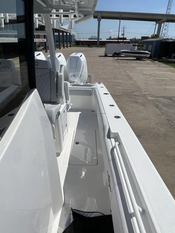 Slide: The Image of 2024 Fountain 38 TE boat, sleek white deck, dual engines, docked in a marina. - 46