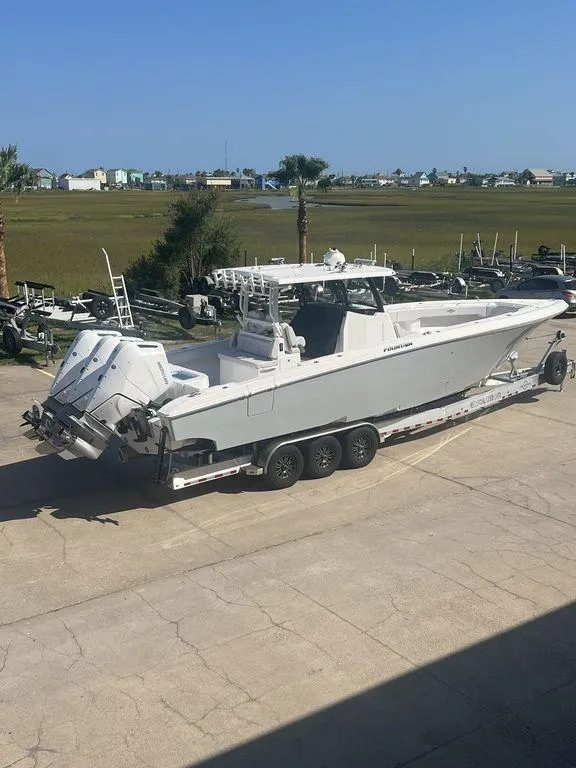 Slide: The Image of 2024 Fountain 38 TE boat on trailer, parked outdoors, with scenic background. - 5