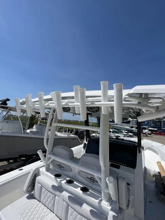 Slide: The Image of 2024 Fountain 38 TE boat with rod holders and seating, under clear blue sky. - 51