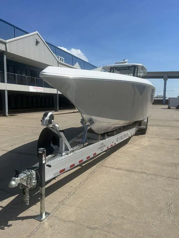 Slide: The Image of 2024 Fountain 38 TE boat on trailer, parked outdoors under clear blue sky. - 6
