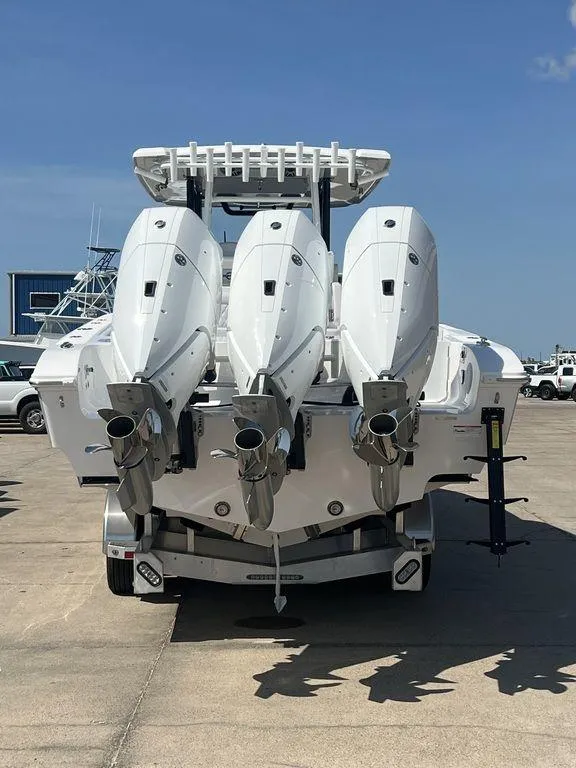 Slide: The Image of 2024 Fountain 38 TE boat with triple outboard engines, docked on a sunny day. - 8