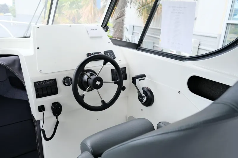 Slide: The Image of 2023 Extreme Boats 745 Game King interior with steering wheel and controls. - 13
